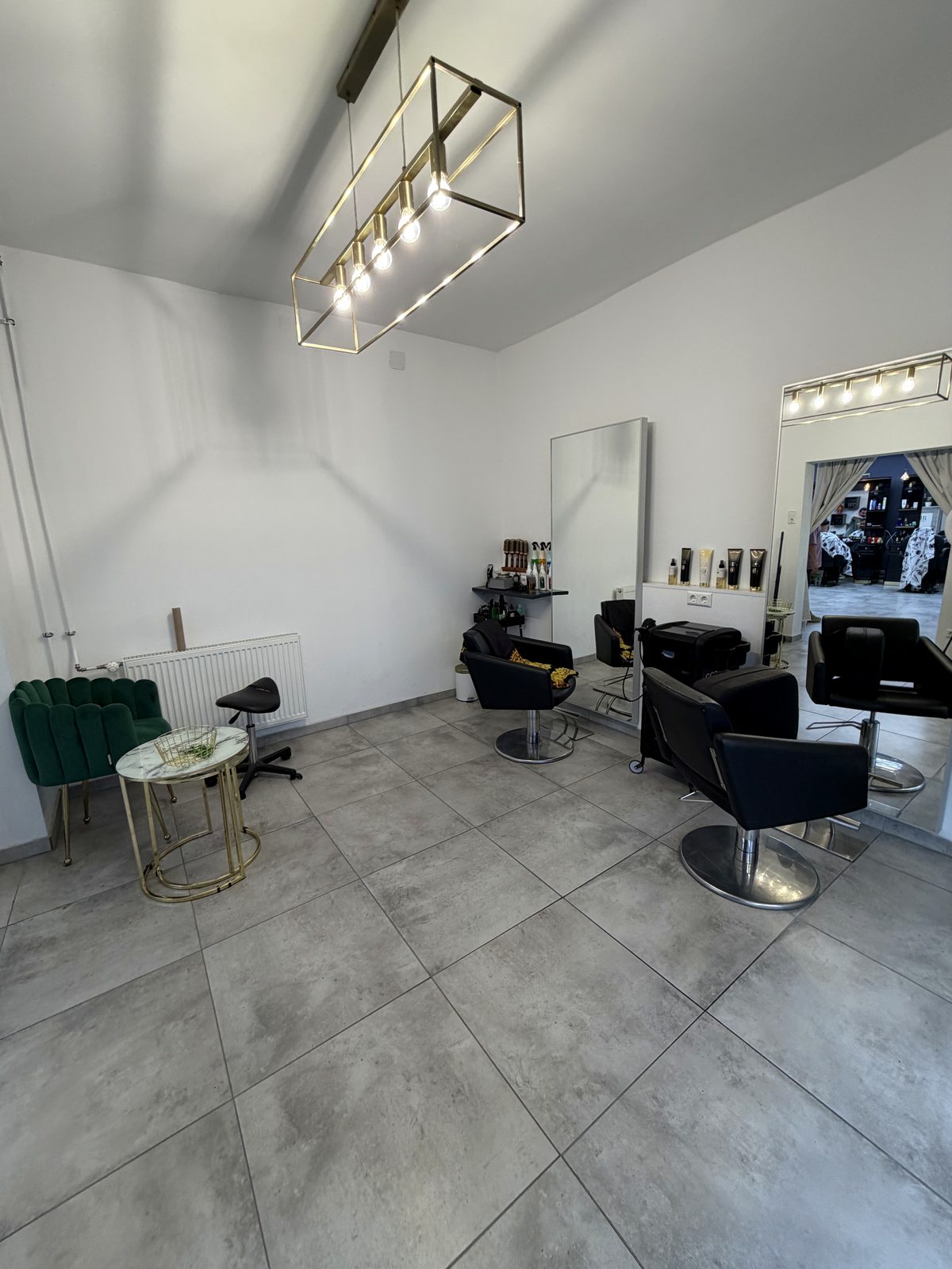 Styling-Bereich mit Gold-Spiegeln und Petrol-Sitzbank im TEMIR Friseursalon